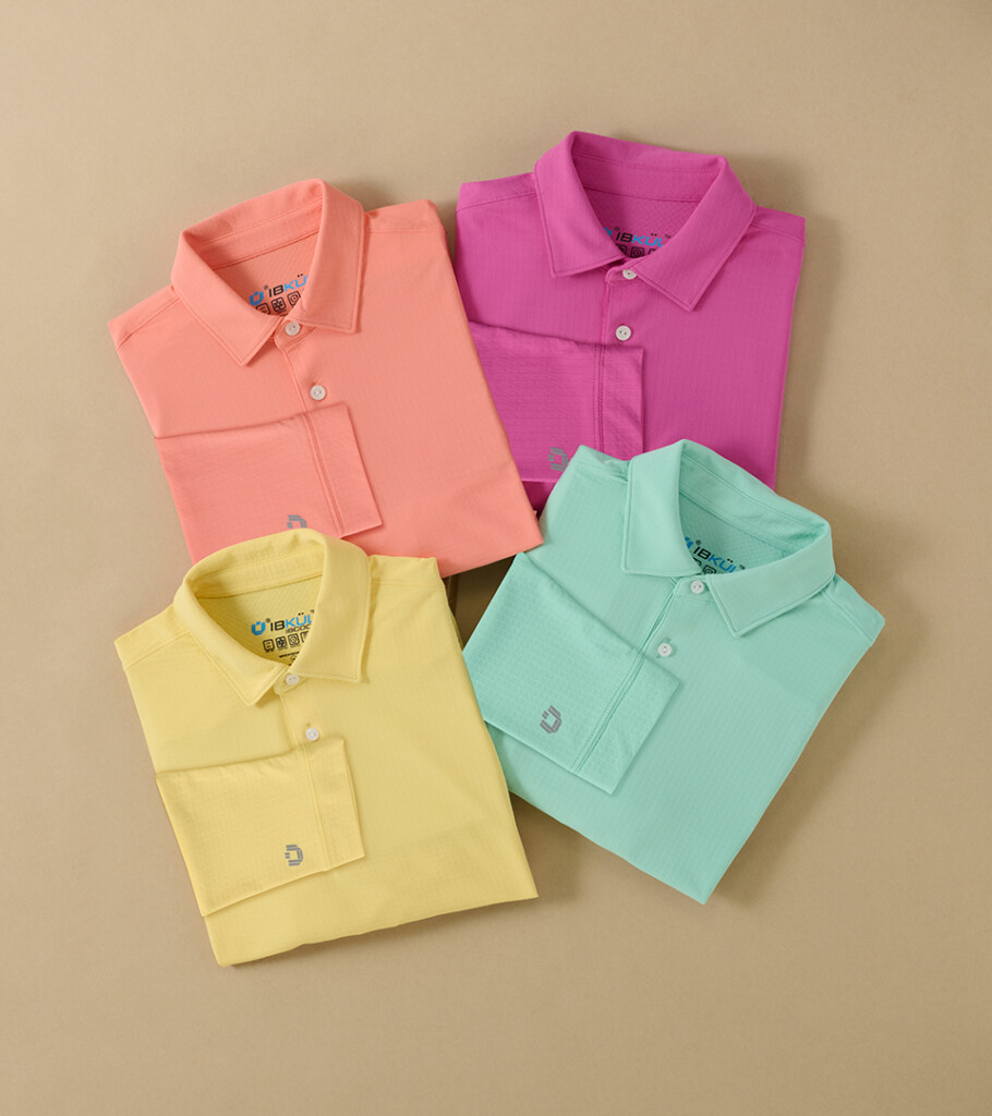 Group flat lay photography of four folded polo shirts in coral, magenta, yellow, and mint on a tan background