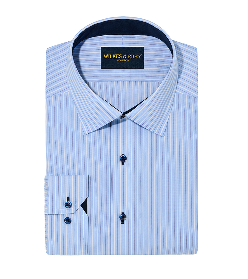 White background product photography of a light blue striped dress shirt folded with cuff detail forward