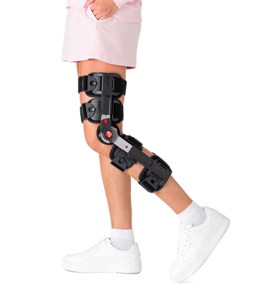 Product photography of a hinged knee brace worn on a leg, side view