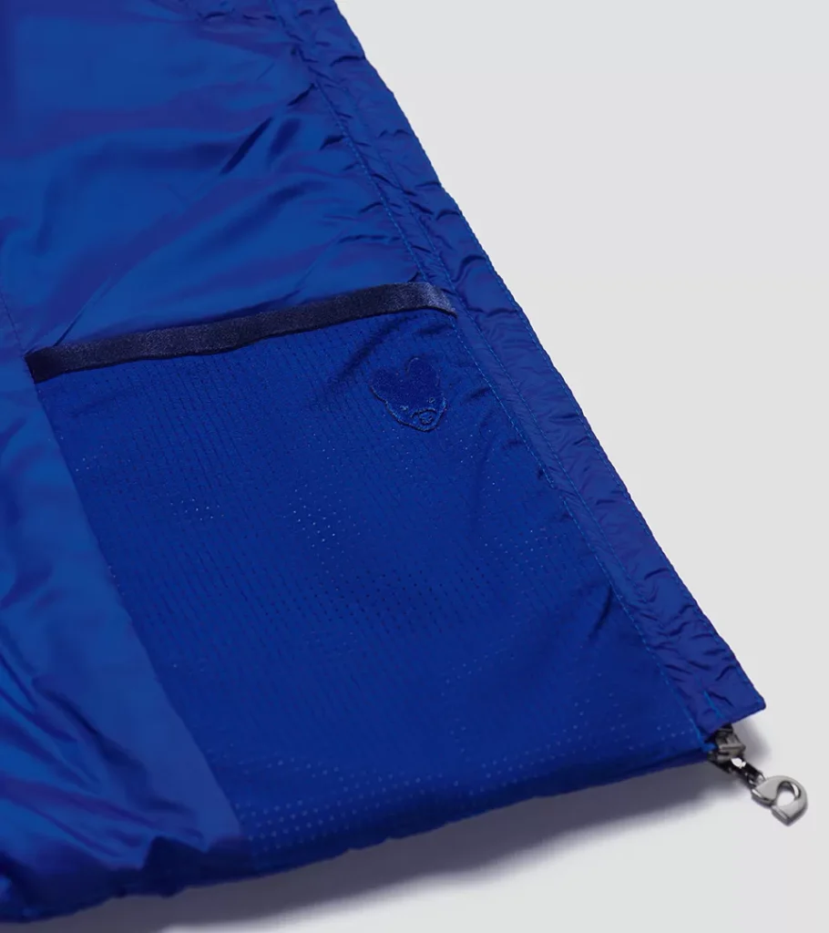 Detail photography of a royal blue jacket zip pocket and perforated fabric