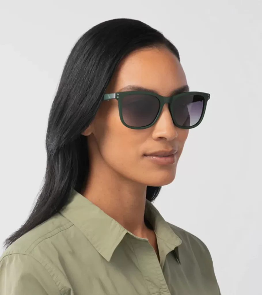 On-model photography of green square-frame sunglasses worn with a sage shirt, portrait view