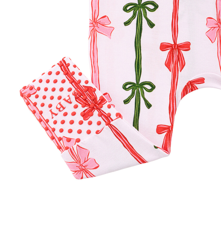 Detail flat lay photography of folded bow-print baby pants showing cuff and dotted lining