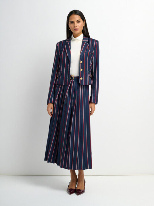 On-model photography of a navy pinstriped blazer and pleated midi skirt set with a slim belt and heels