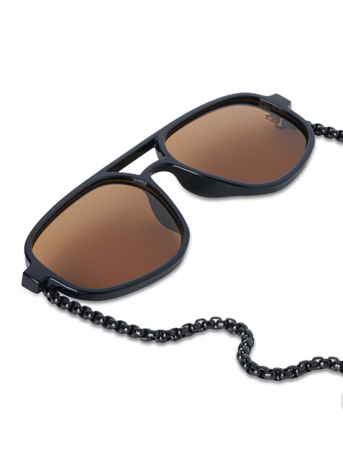 Close-up product photography of black aviator sunglasses with brown lenses and a black beaded chain, angled view