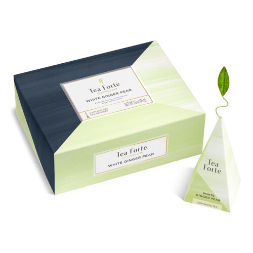 Product photography of a closed green and navy tea gift box beside a white pyramid tea sachet