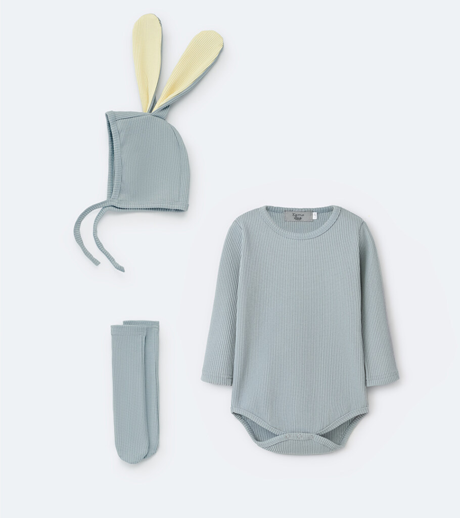 Flat lay photography of a grey baby set with bunny-ear bonnet, bodysuit, and socks