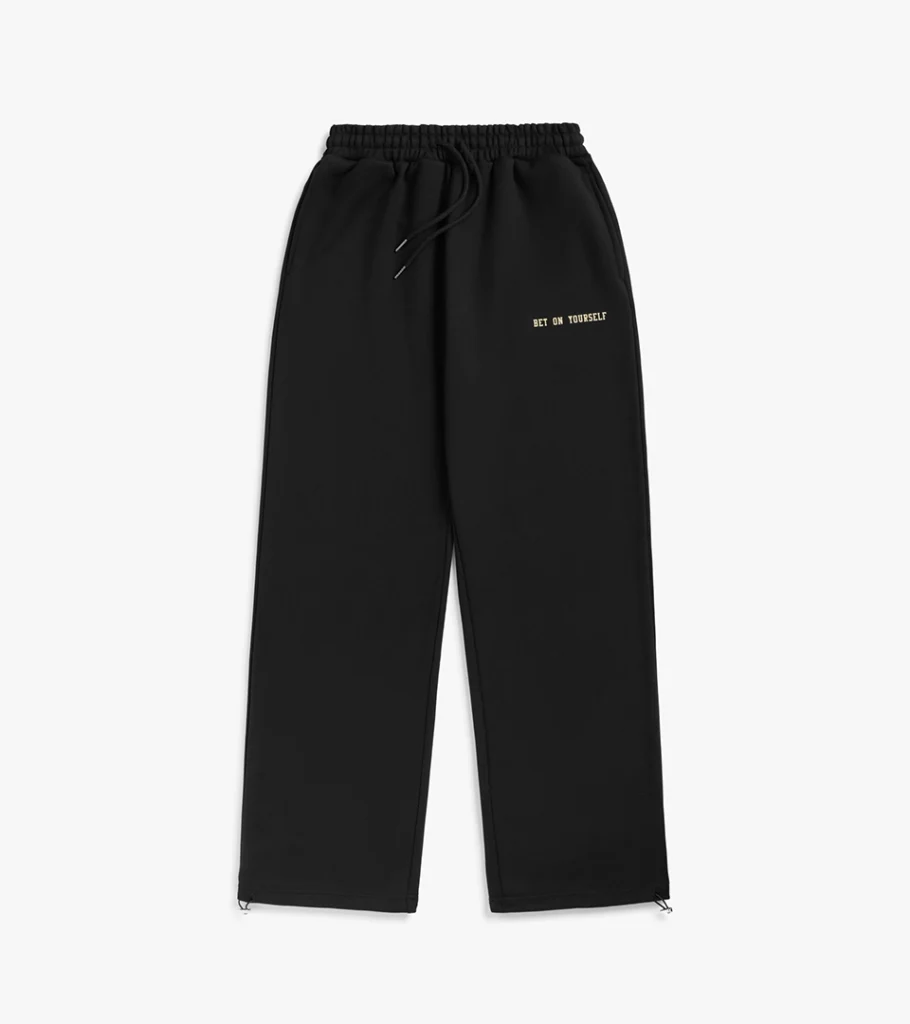 Flat lay photography of black drawstring sweatpants with embroidered text