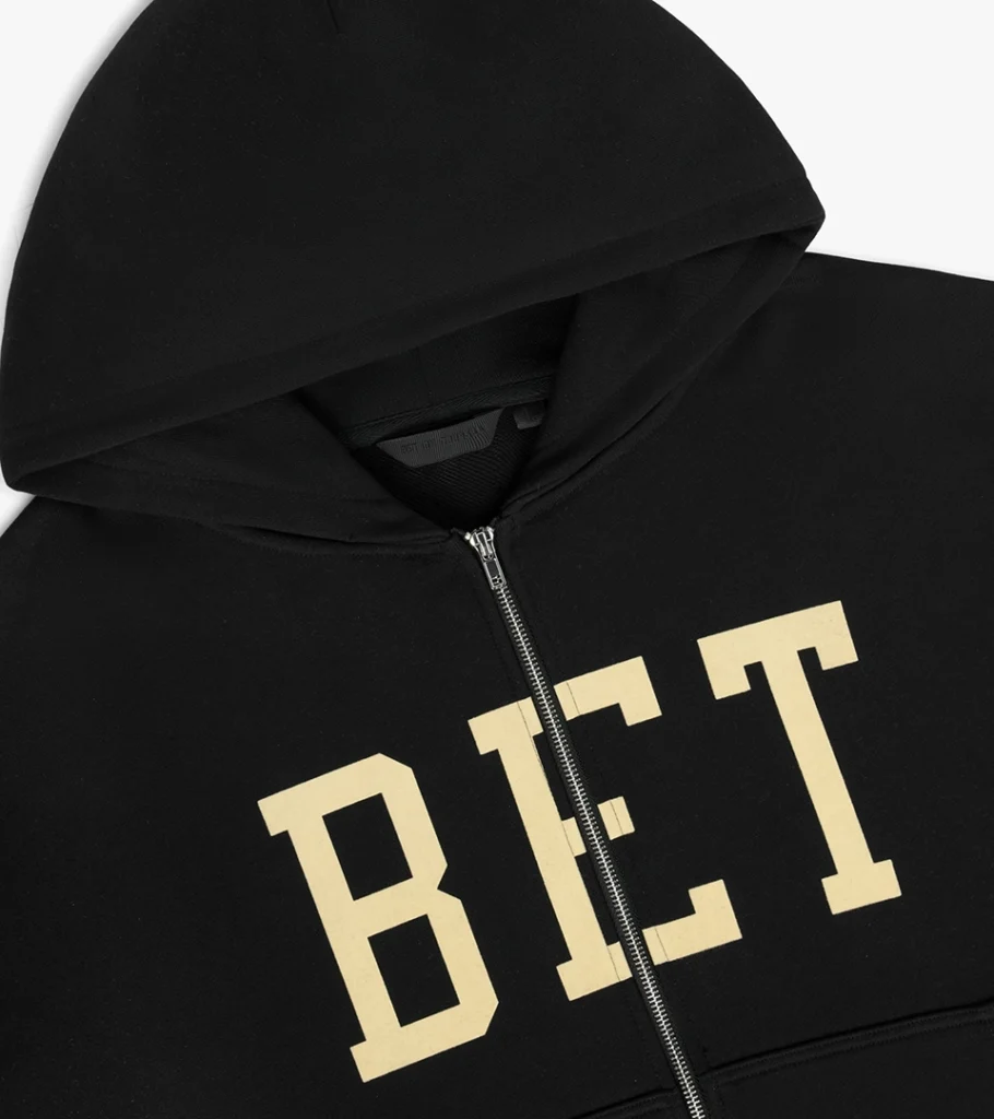 Detail flat lay photography of a black zip hoodie with varsity letter print