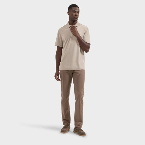 Full-length shot of model in beige polo and tan trousers with brown loafers