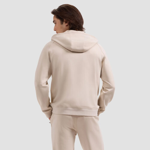 Back view of model in cream zip-up hoodie showing hood and shoulder fit
