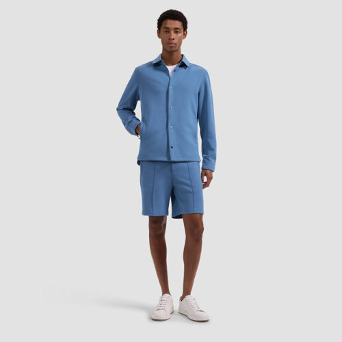 Model in blue zip jacket and matching shorts, full-length front view