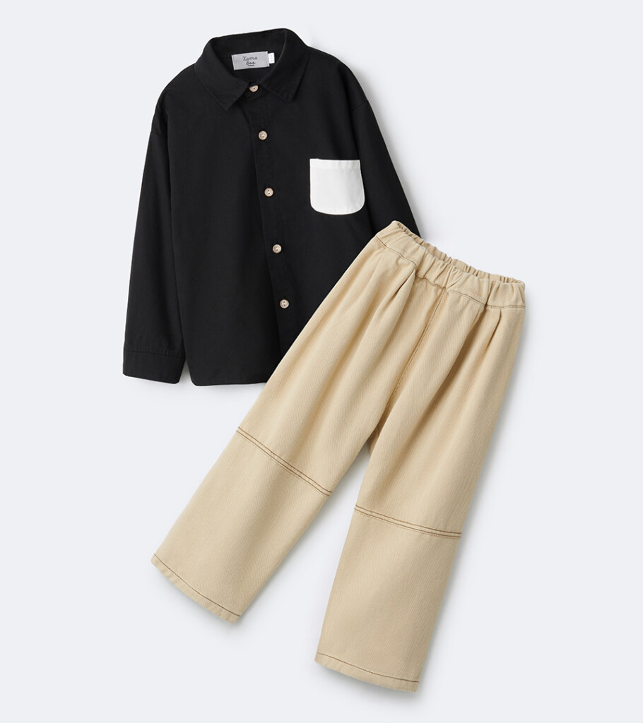 Flat lay photography of a kids outfit set with a black button shirt and beige pants