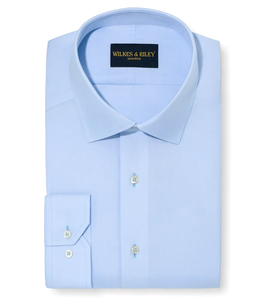 Flat lay photography of a folded light blue dress shirt for online retail apparel photography.