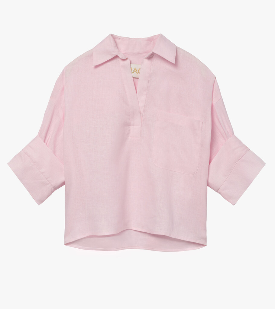 Flat lay photography of a pink popover blouse with rolled cuffs