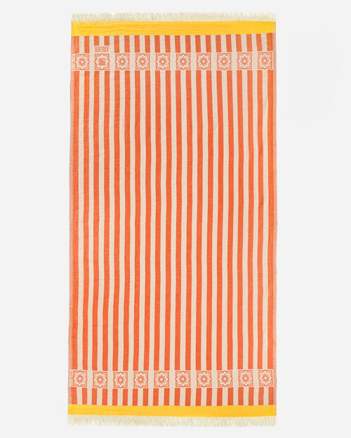 Flat lay photography of a orange and cream striped towel with a teal border band, shown full length