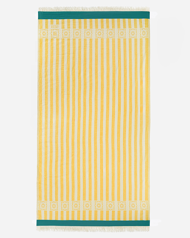 Product photography of a yellow and white vertical striped towel, laid flat