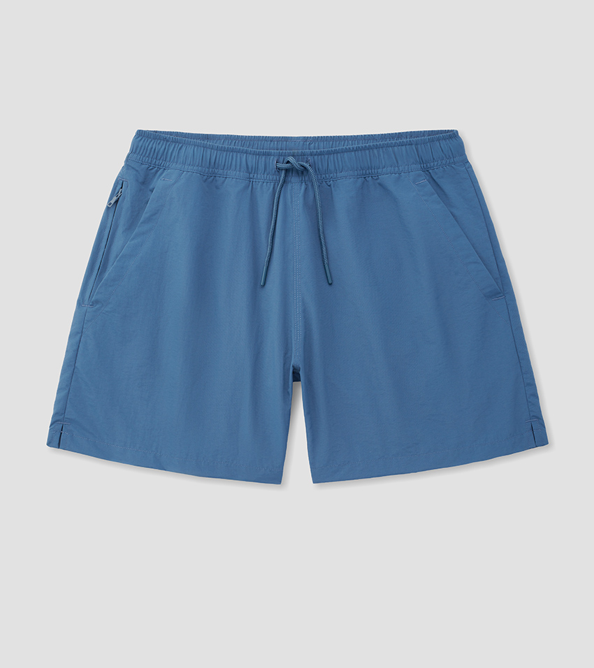 Flat lay photography of mid-blue swim shorts with a tonal drawstring waistband, laid flat and pressed