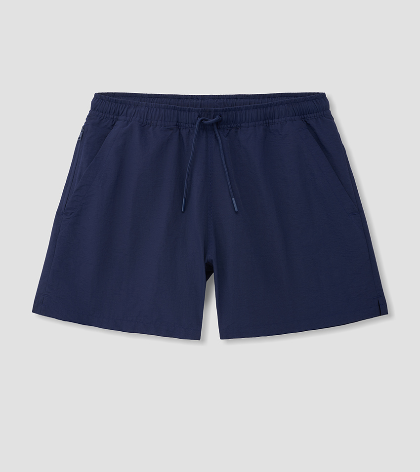 Flat lay photography of navy swim shorts with an elasticated drawstring waistband, laid flat and pressed