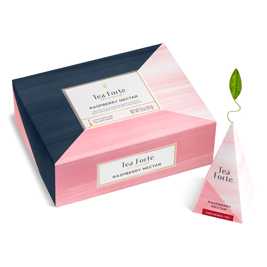 Product photography of a closed pink tea carton with a single pyramid sachet standing beside it