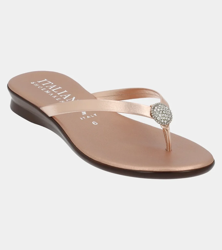 Automated product photography of a blush metallic leather thong sandal on a low wedge sole, straight profile view