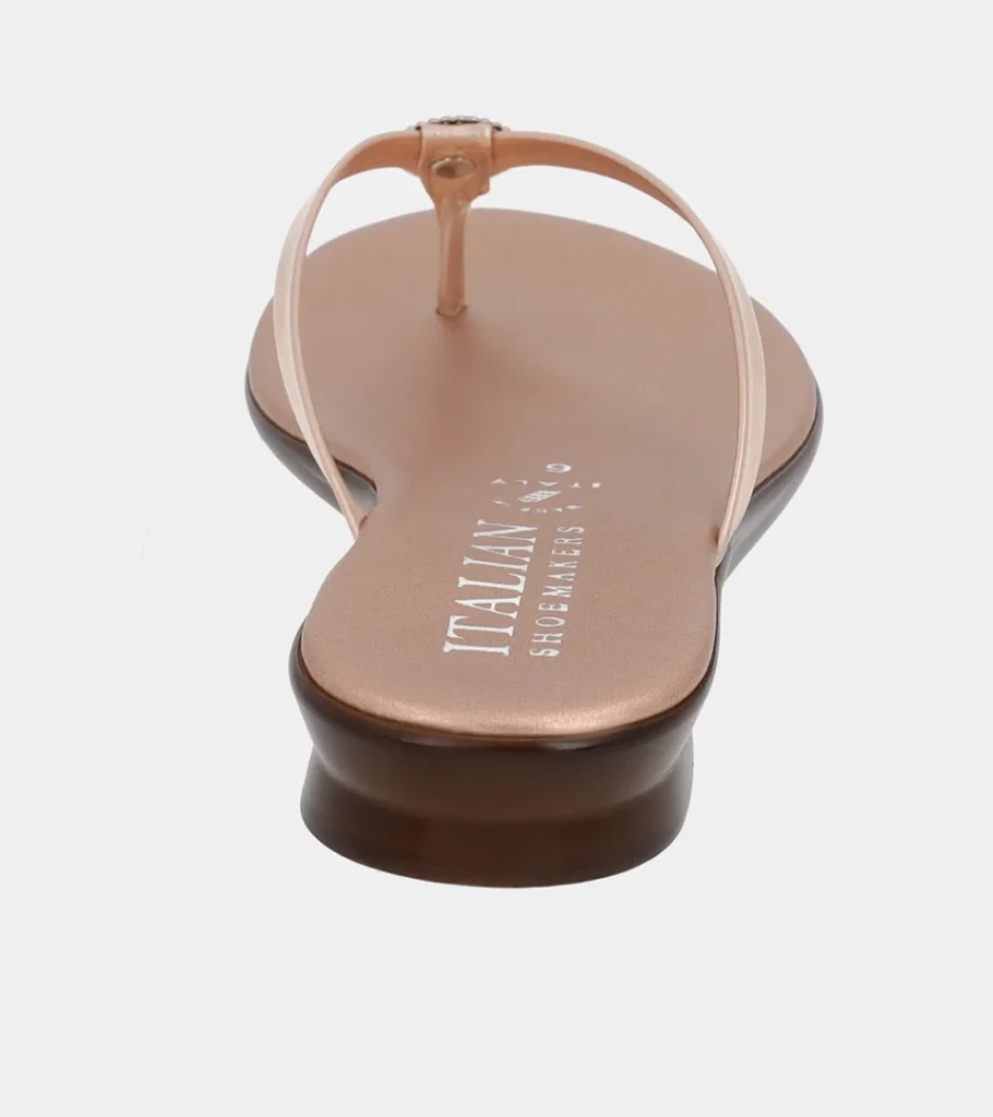 Automated product photography of a blush metallic leather thong sandal seen head-on from the toe, front view