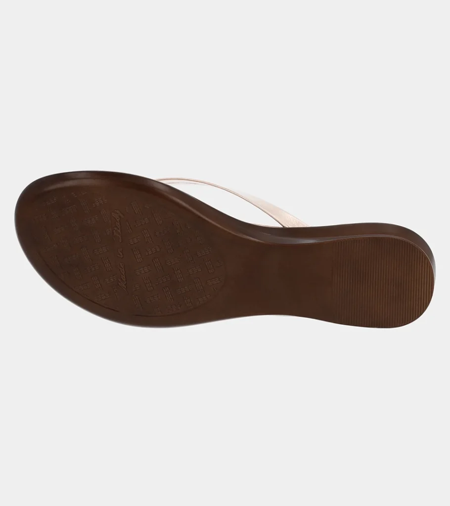 Automated product photography of the dark brown outsole of a blush metallic leather thong sandal, underside view