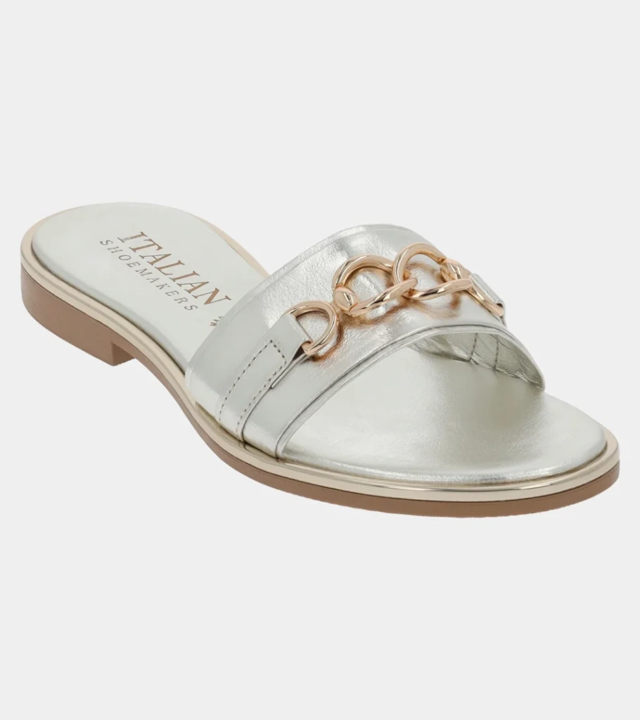 Automated product photography of a silver metallic leather slide sandal with a gold chain-link ornament, angled side view
