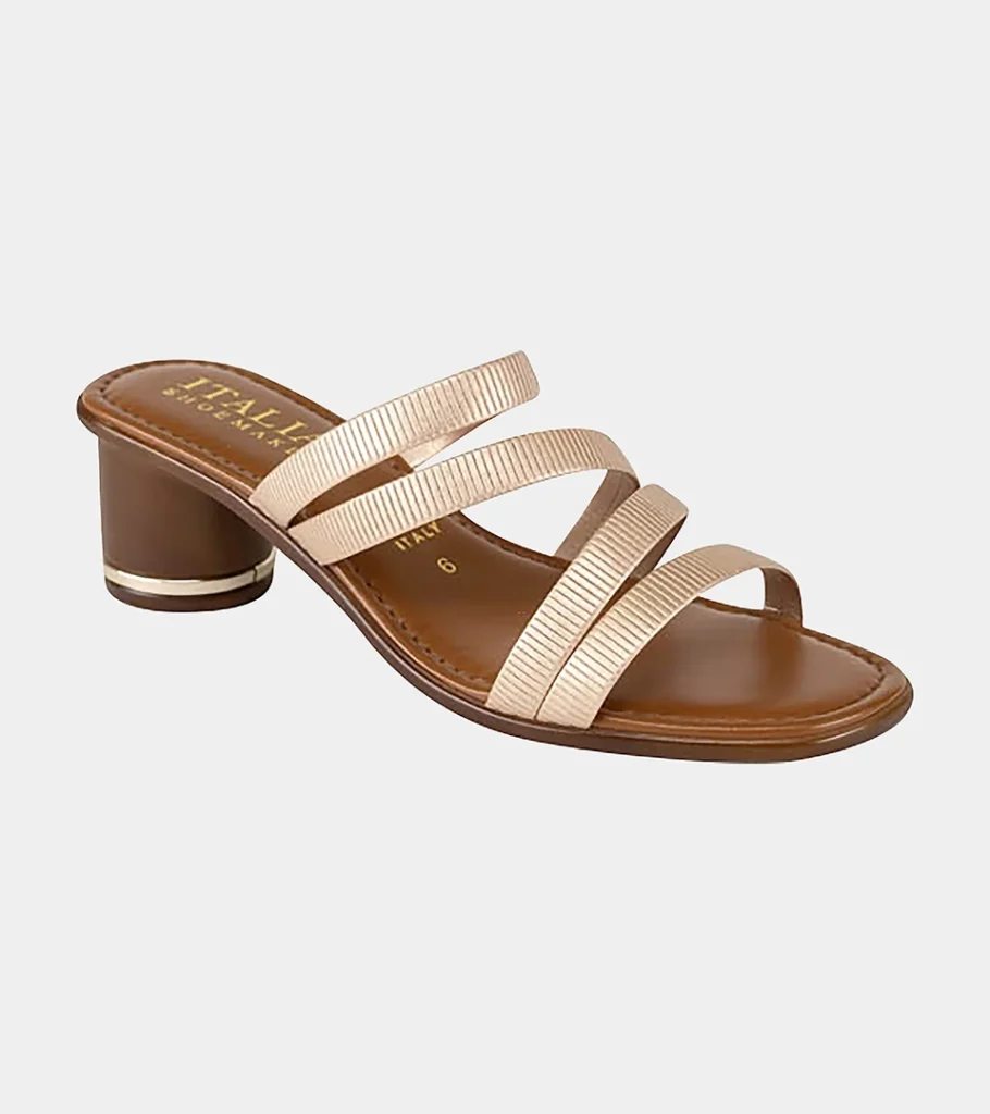 Automated product photography of a tan leather slide sandal with cream crossover straps and a low block heel, angled side view