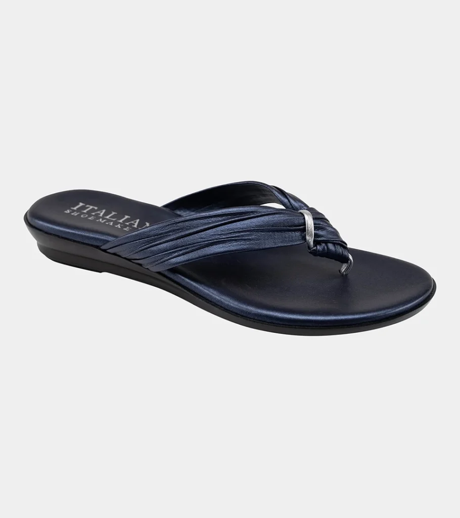 Automated product photography of a navy metallic thong sandal with braided straps on a low wedge sole, side view