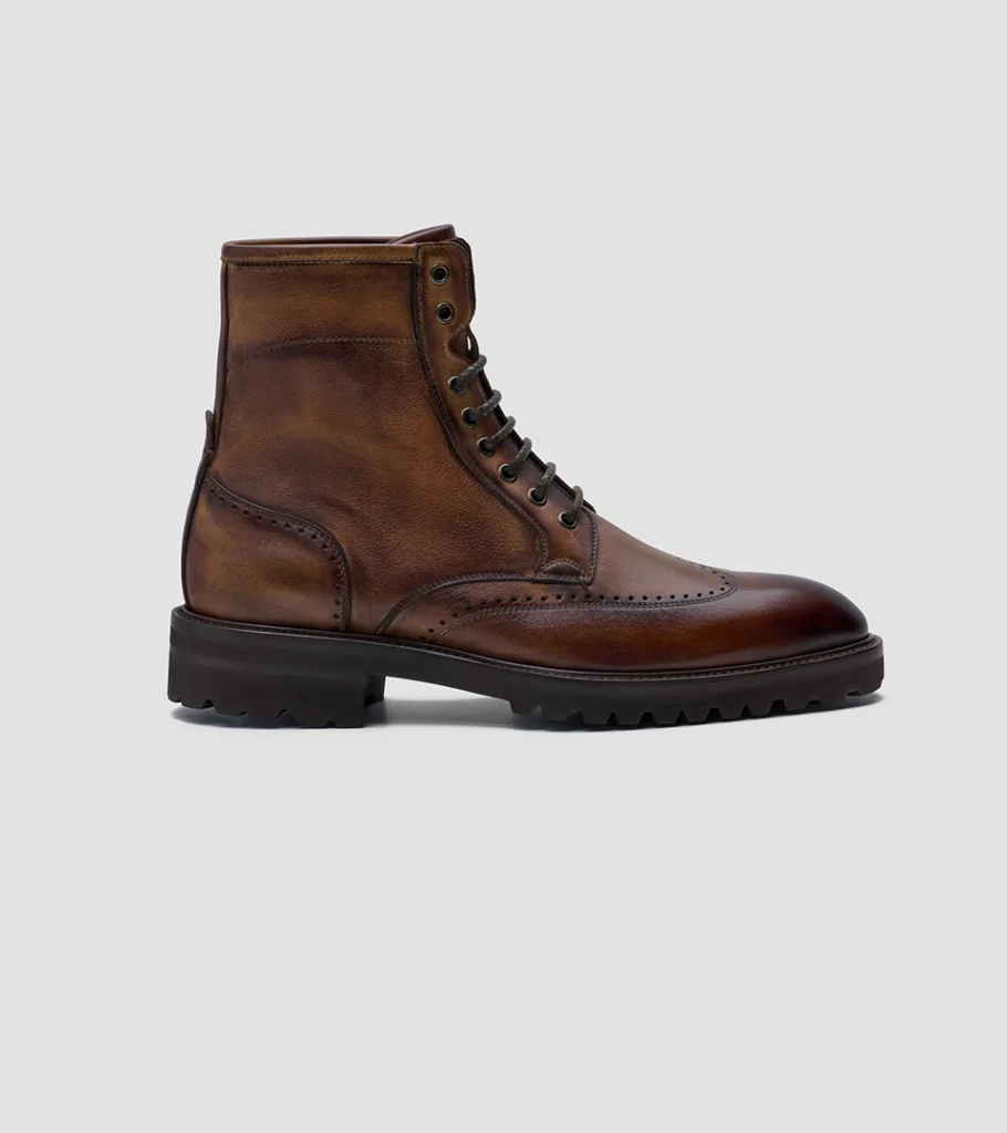 Shoe product photography of a brown leather lace-up boot in side profile on a lugged rubber sole