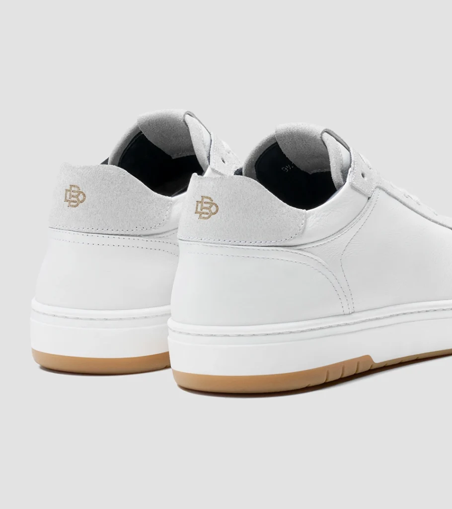 Shoe product photography of a pair of white leather sneakers viewed from behind showing the heel counters