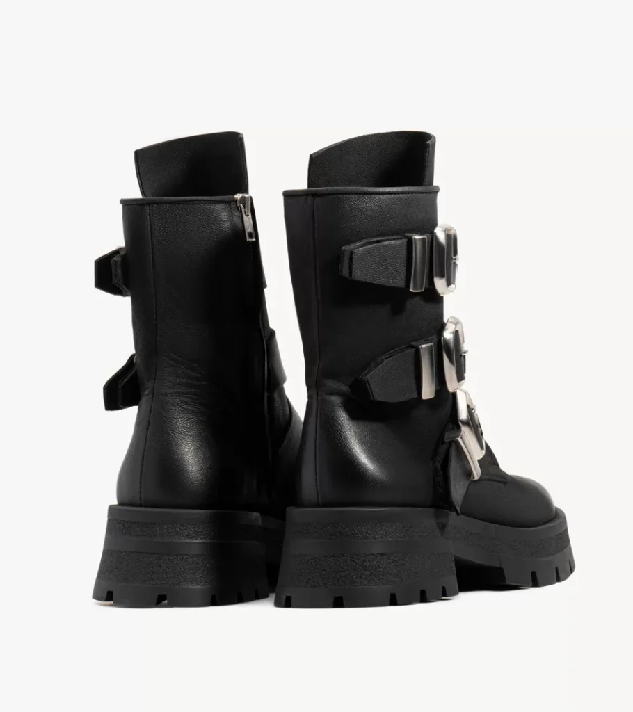 Shoe product photography of a pair of black buckled boots viewed from behind showing heel counters and lugged soles