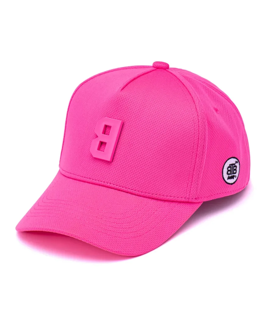 Product photography of a hot pink baseball cap with a raised rubber logo badge, angled view