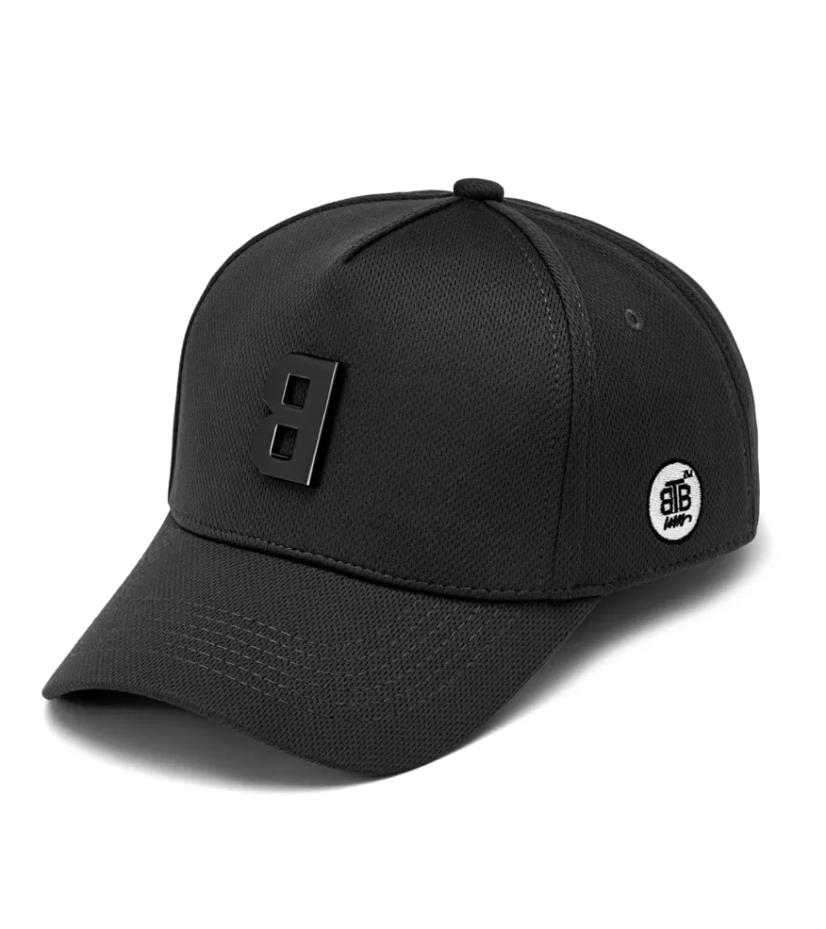 Product photography of a black structured baseball cap with a black metal logo badge, side view
