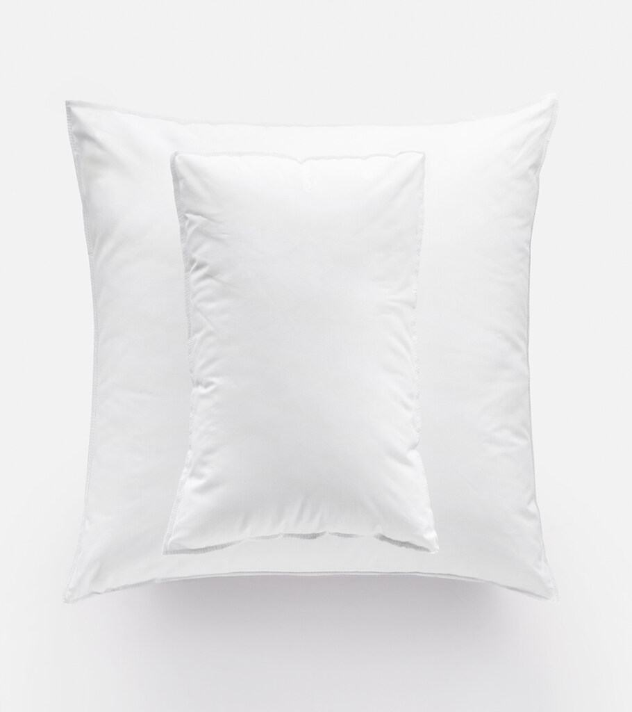 Product photography of a white square pillow with a soft sheen and visible seam, front view on white