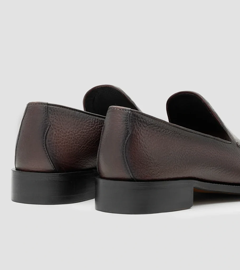 Shoe product photography of a pair of dark brown leather loafers viewed from behind at a three-quarter angle