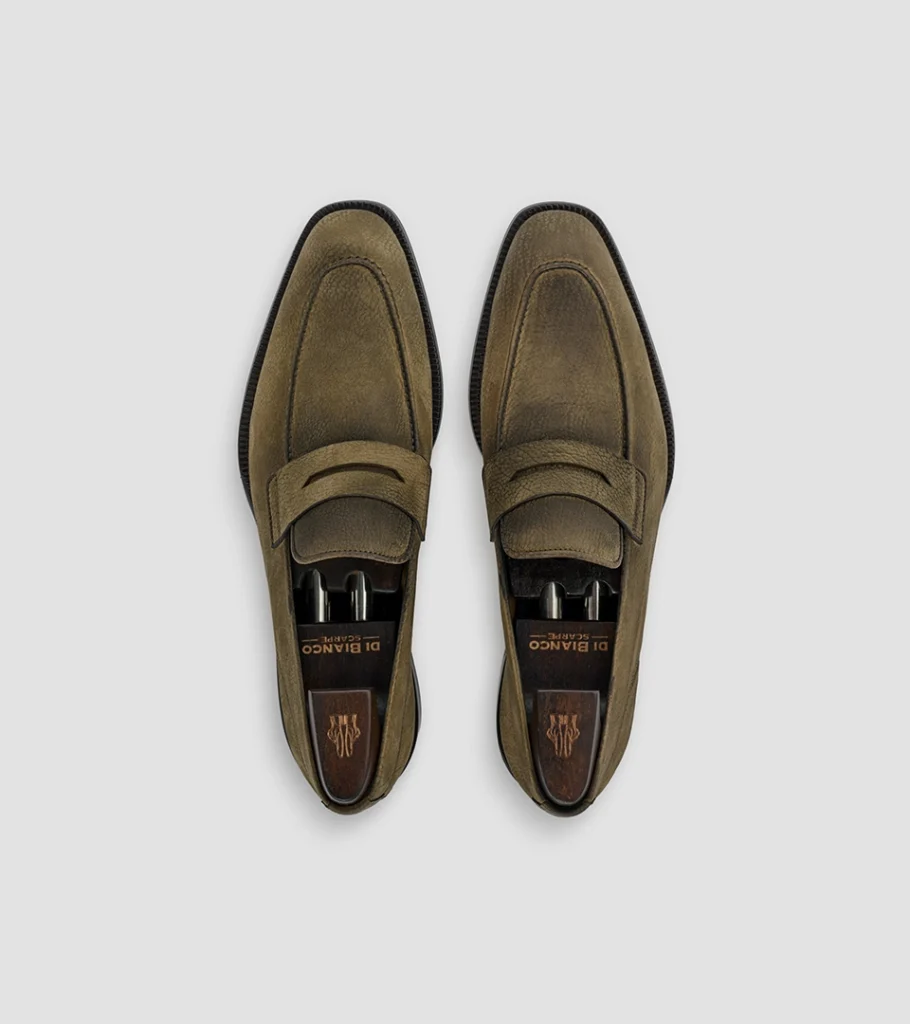 Shoe product photography of a pair of olive suede penny loafers shot from directly overhead
