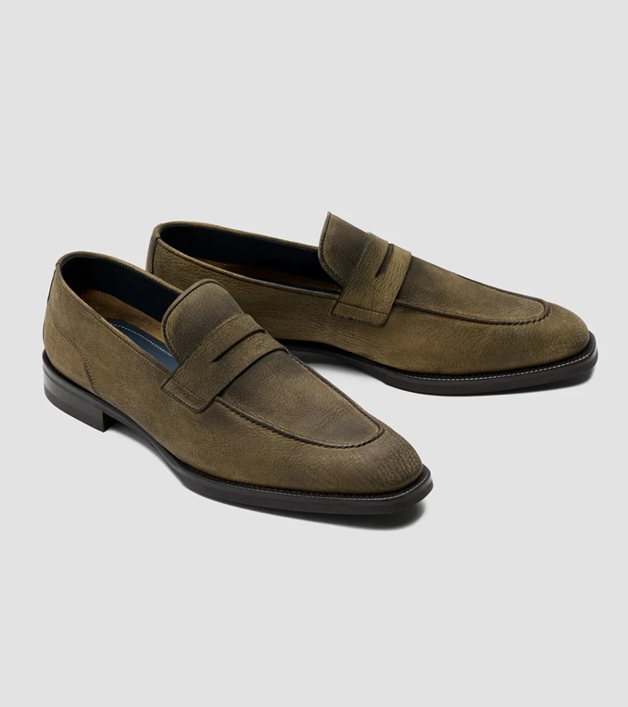 Shoe product photography of an olive suede penny loafer at a front three-quarter angle