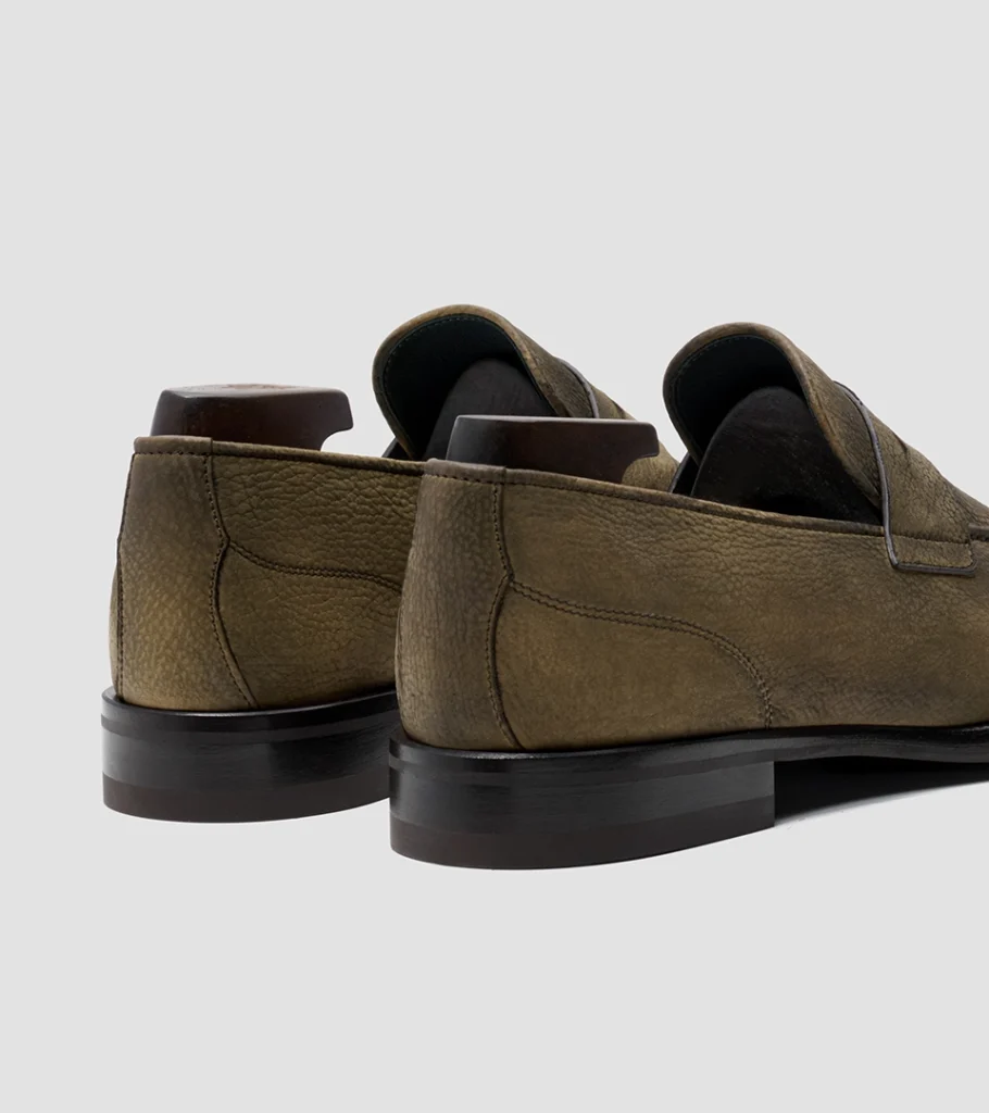 Shoe product photography of a pair of olive suede loafers viewed from behind at a three-quarter angle