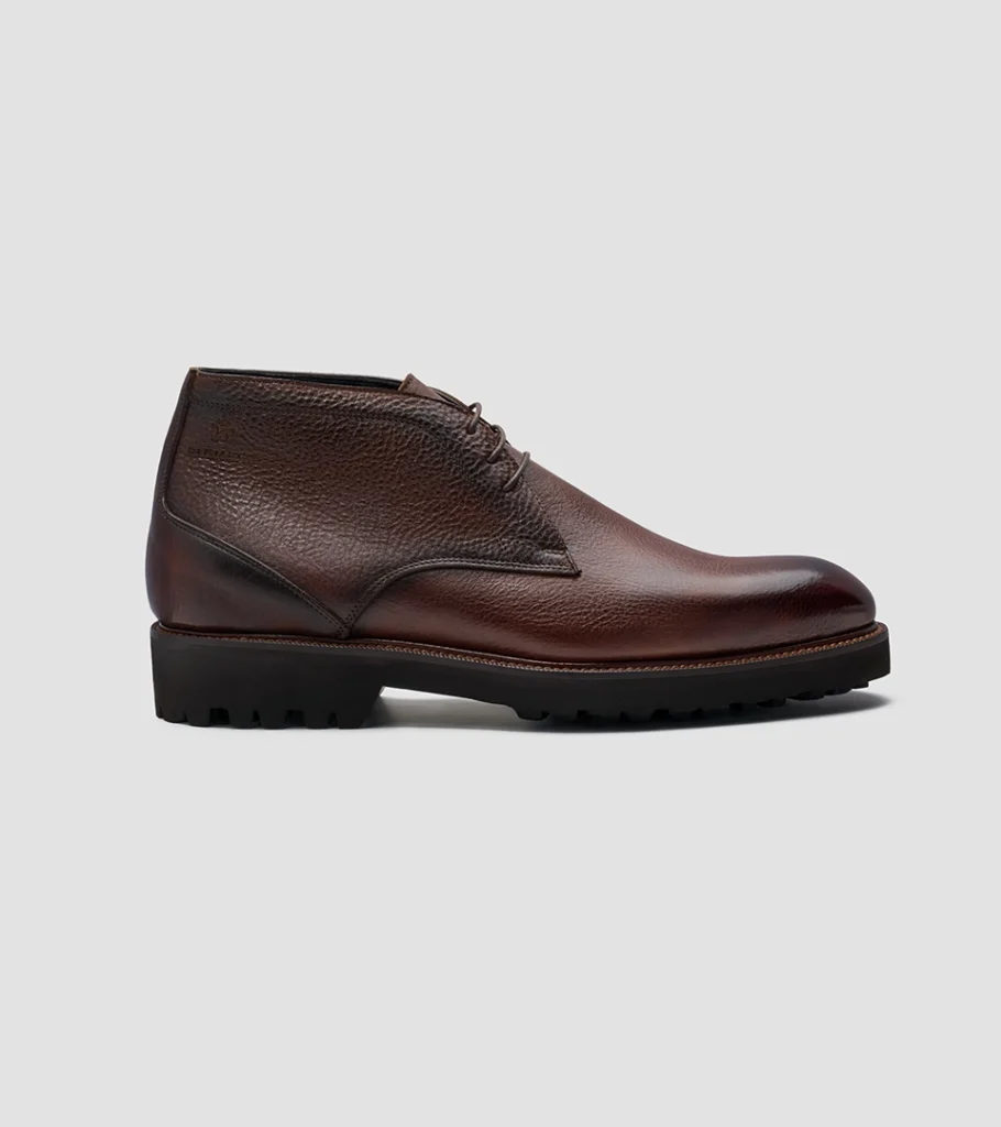 Shoe product photography of a burgundy leather lace-up boot in side profile on a lugged sole