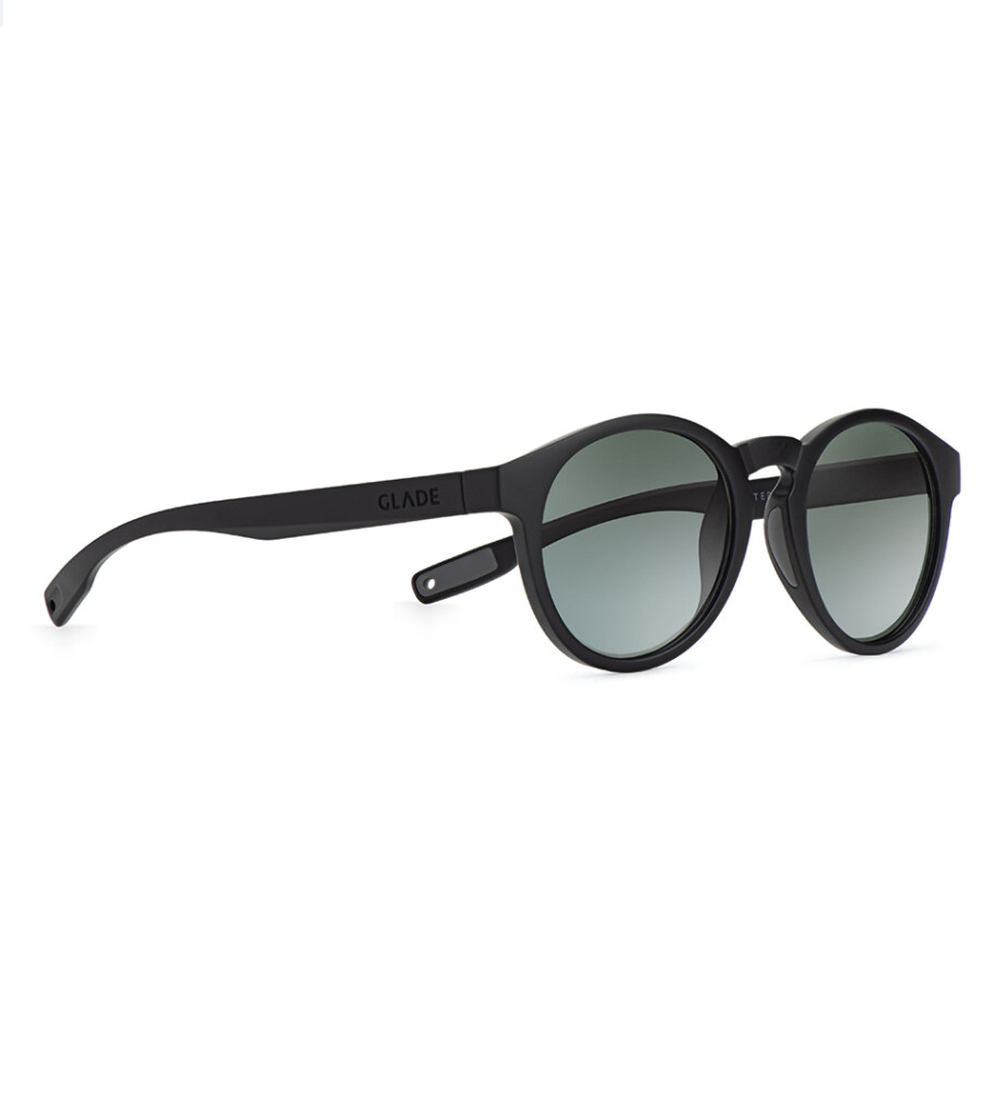 Product photography of round black sunglasses with green gradient lenses, angled view
