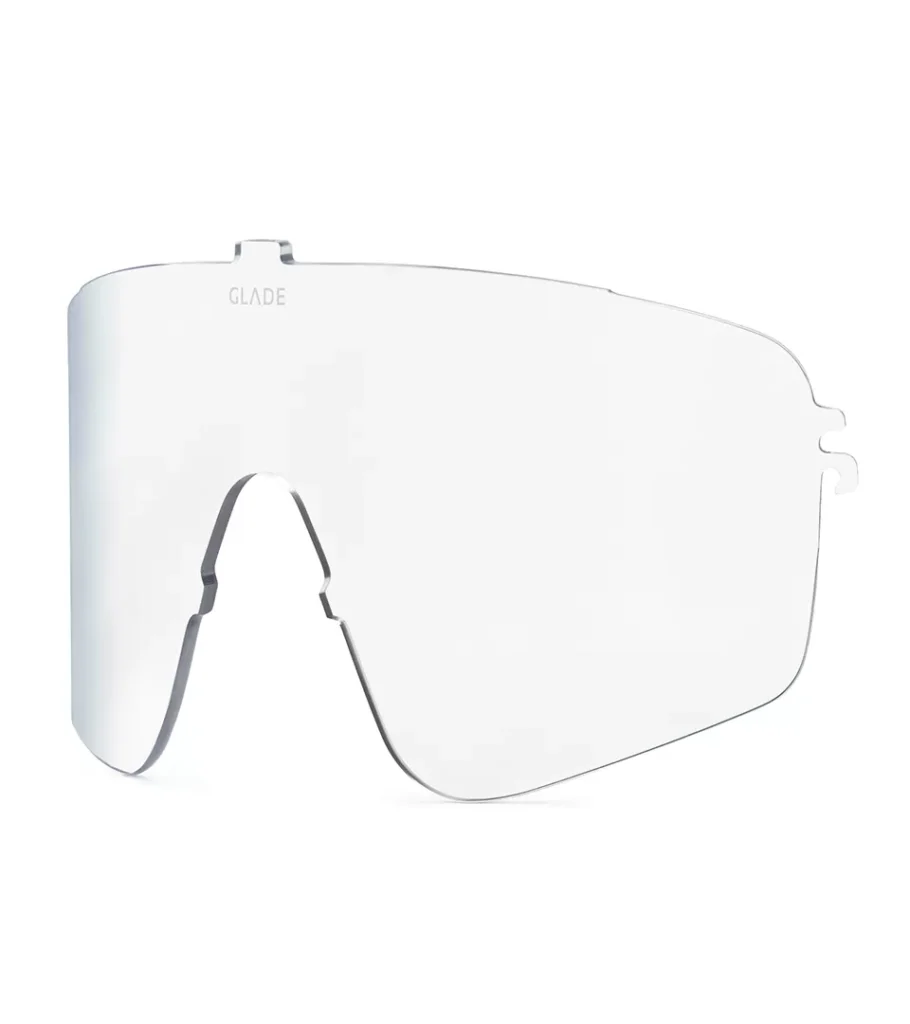 Product photography of a clear tapered replacement lens for snow goggles, angled side view