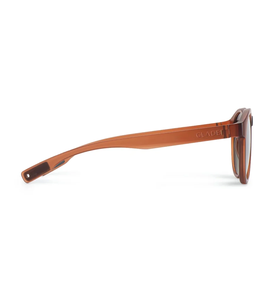 Product photography of round amber sunglasses in straight side profile showing the temple arm and lens edge