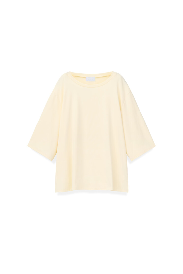 Flat lay and creative laydown product photography studio. Pale yellow oversized boxy t-shirt on a clean white background.
