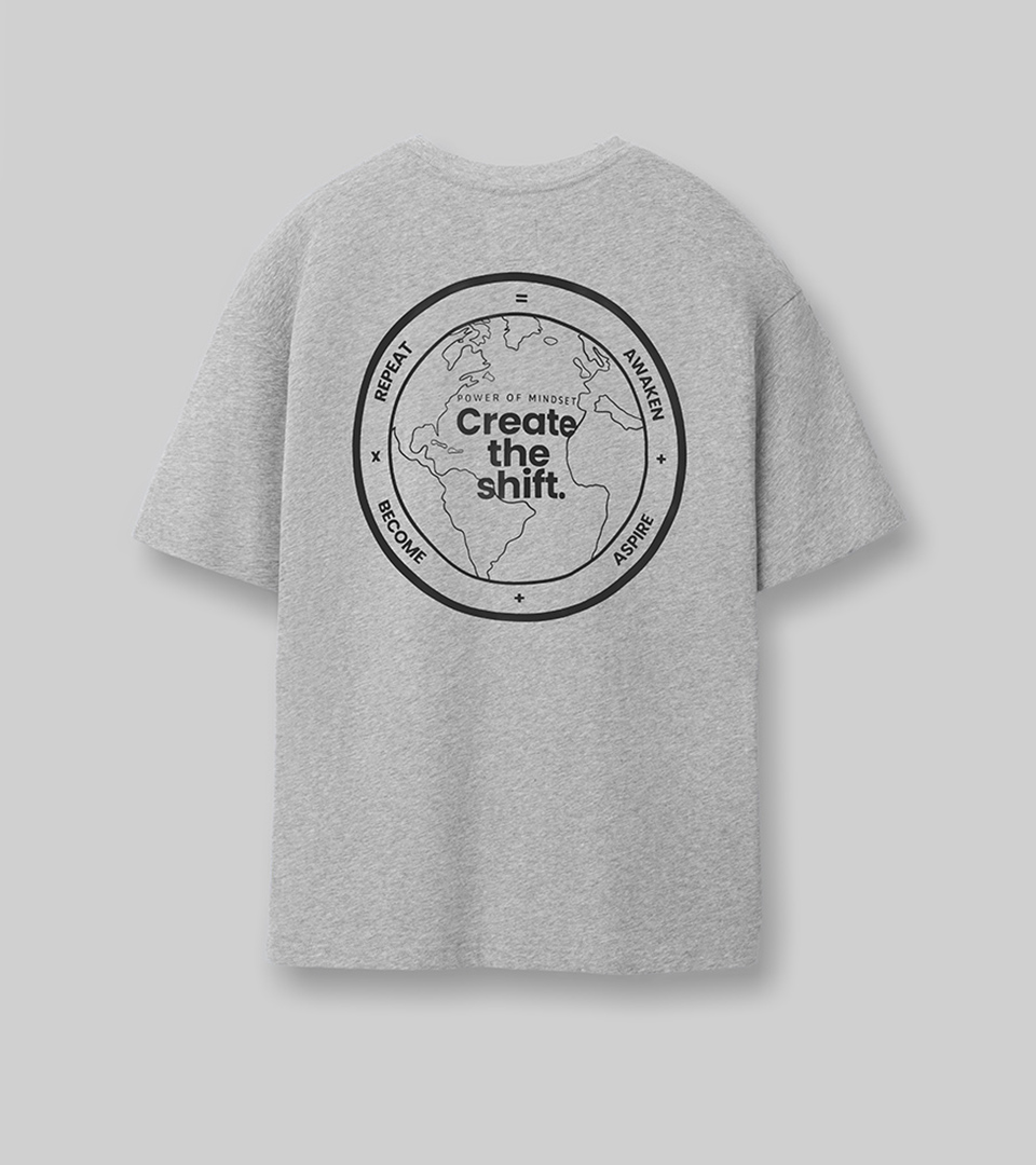 Flat lay fashion product photography by Shootify. Grey heather t-shirt with 'Create the shift' globe graphic shot flat on a grey background for Power of Mindset.