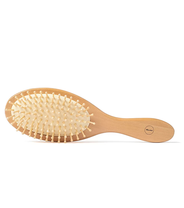 Product photography of a wooden paddle hairbrush with rounded wooden pins, bristle-side view on white.