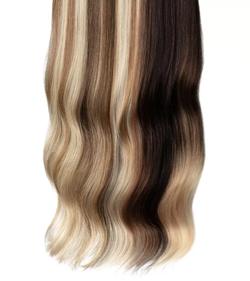 Detail photography of wavy hair extension strands in highlighted blonde and dark brown shades, close-up showing texture and color transition.
