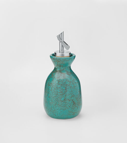 Studio product photography of a turquoise speckled ceramic oil pourer with a stainless steel spout.