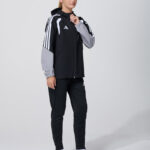 Female model in black and grey adidas track jacket and pants