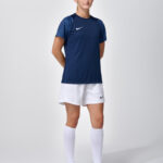 Female model in navy Nike soccer jersey and skort